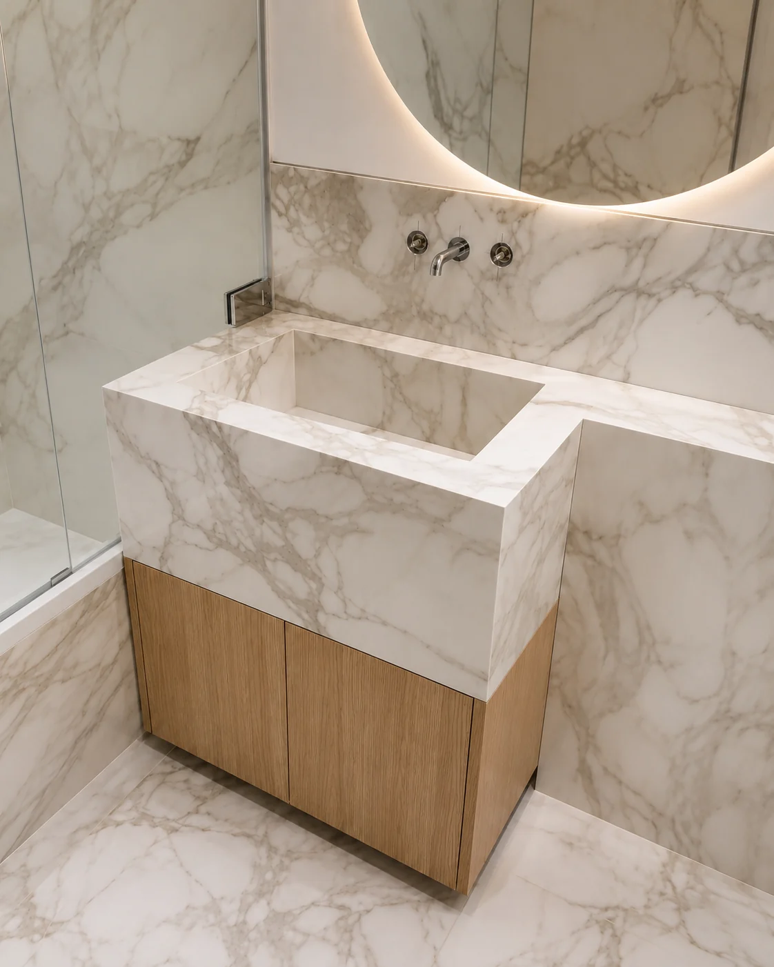 Porcelain with an Arabescato pattern bathroom with illuminated mirror and taps mounted on the wall