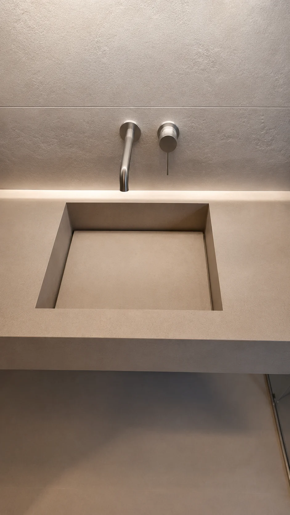 Minimal bathroom with floating porcelain sink and matching stone pattern surfaces