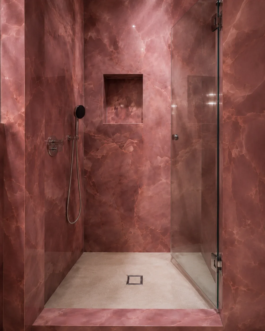 Rose porcelain with an onyx pattern shower wall with niche detail.