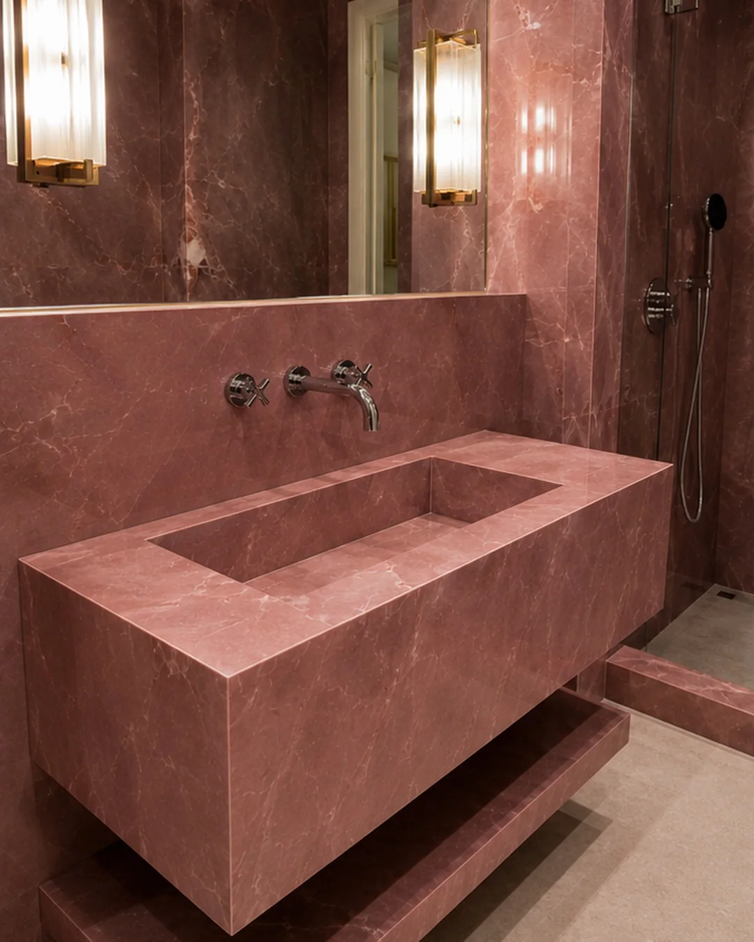 Completed rose onyx-effect porcelain sink with an integrated basin and wall-mounted bronze taps